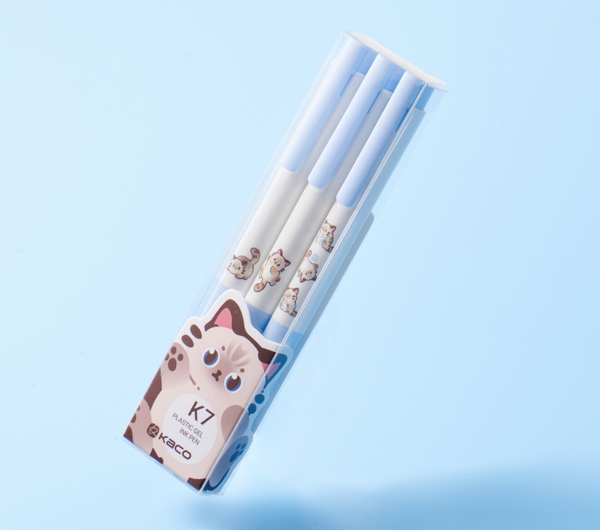 Kitten set in its clear K7 box, three light blue and white pens, on a light blue background